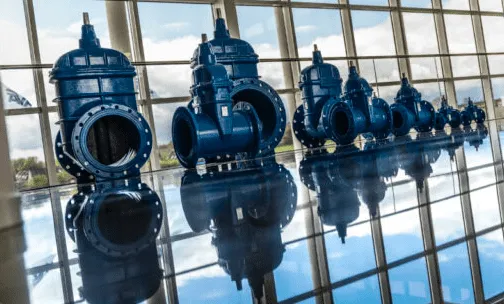 Kontainer DAM case thumbnails: AVK Large blue AVK industrial parts on a blank floor with a window facade behind