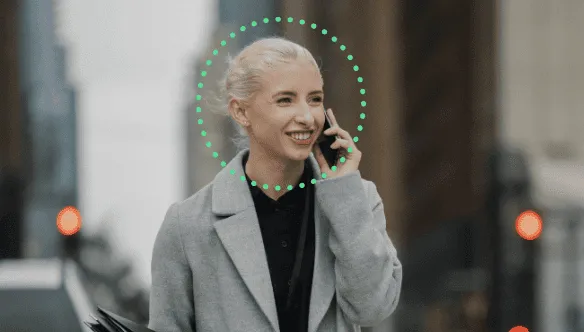 Consent_management_DAM_v7 A woman talking on the phone while walking down the street. Face recognition.